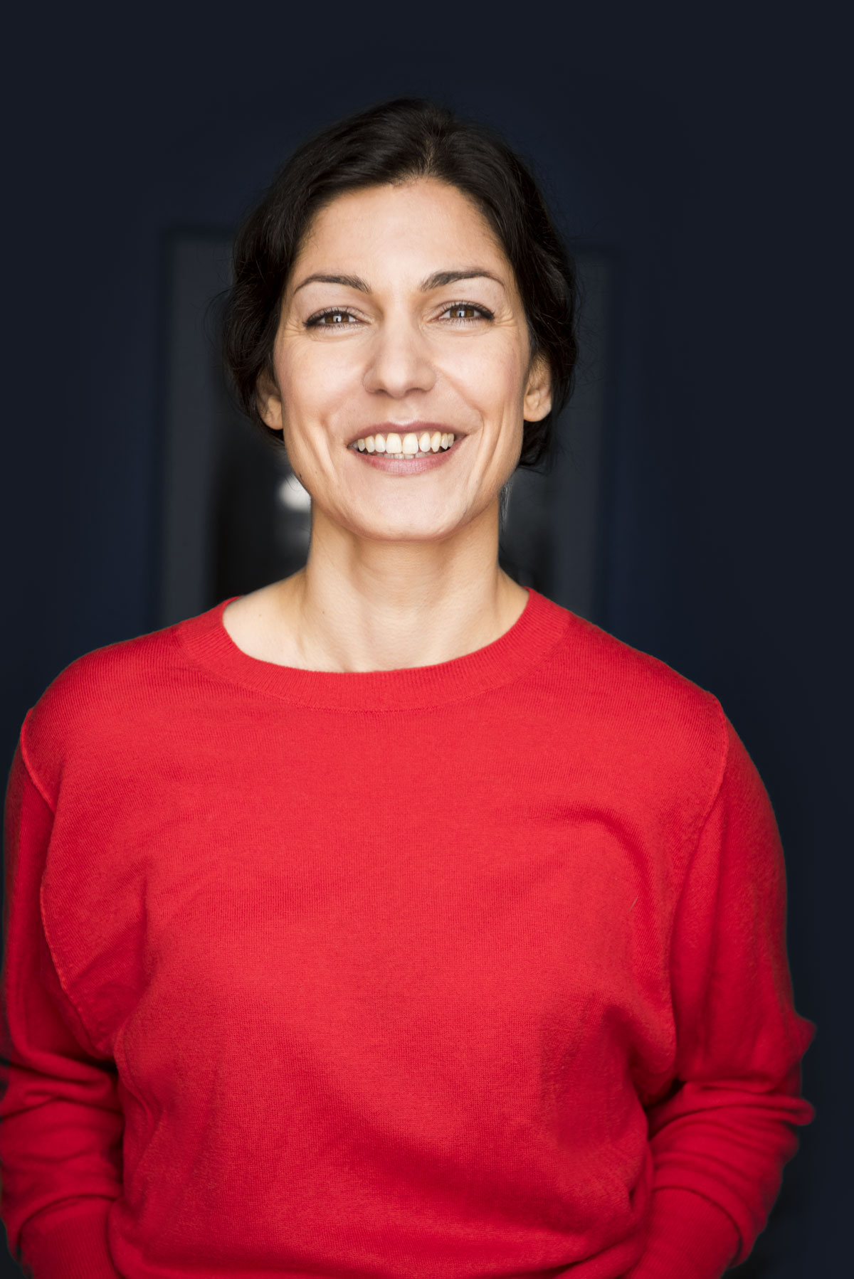 Halbtotale von Anna Pfingsten Sahagian in einem gemütlichen Raum mit einem Bild an der Wand.